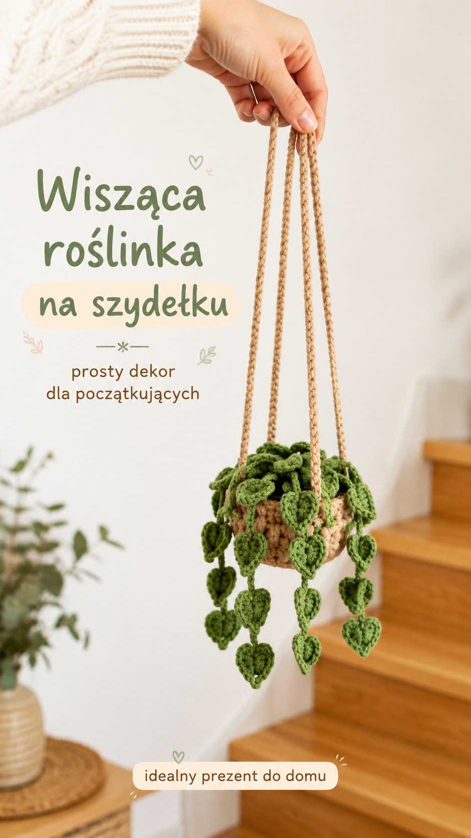 Wisząca szydełkowa roślinka z listkami w kształcie serca zwisająca z dłoni na tle drewnianych schodów